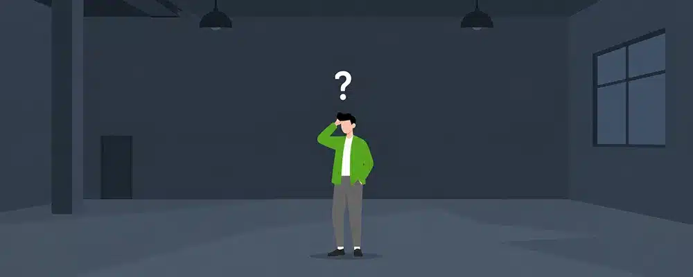 Business owner standing alone in a dark office with a question mark overhead, symbolising Brisbane IT services left unmonitored